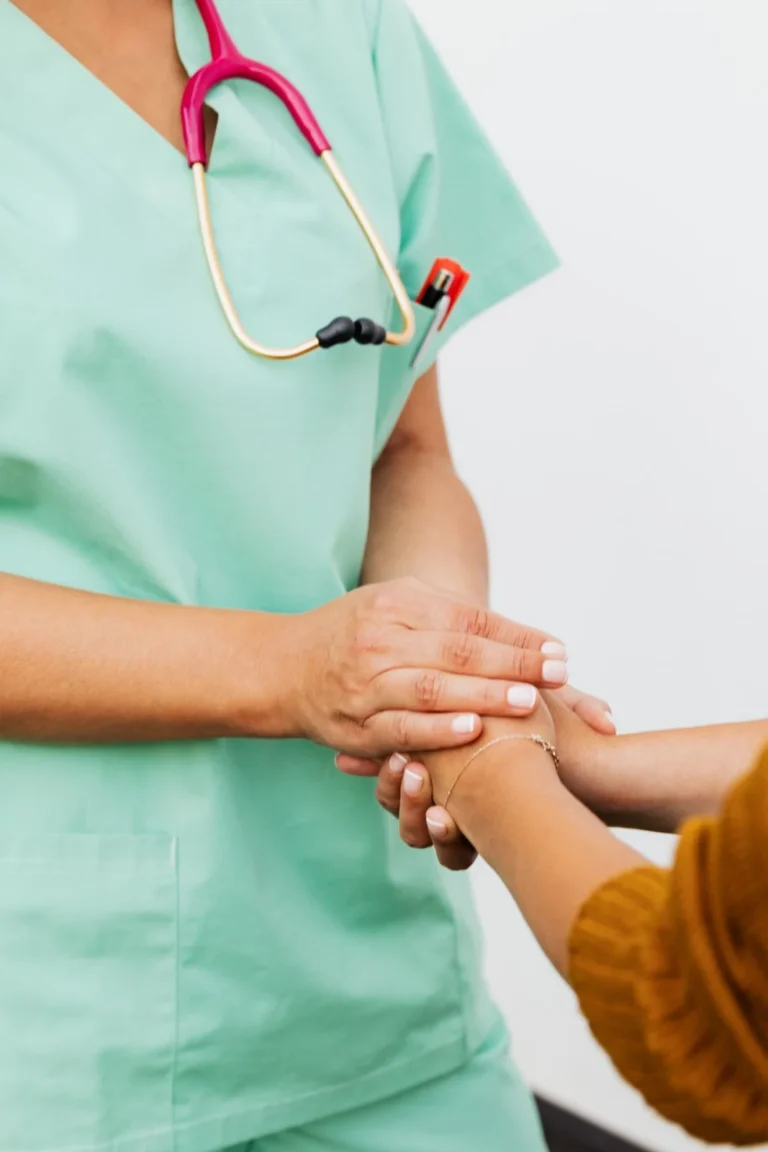 Enfermera sosteniendo la mano de un paciente